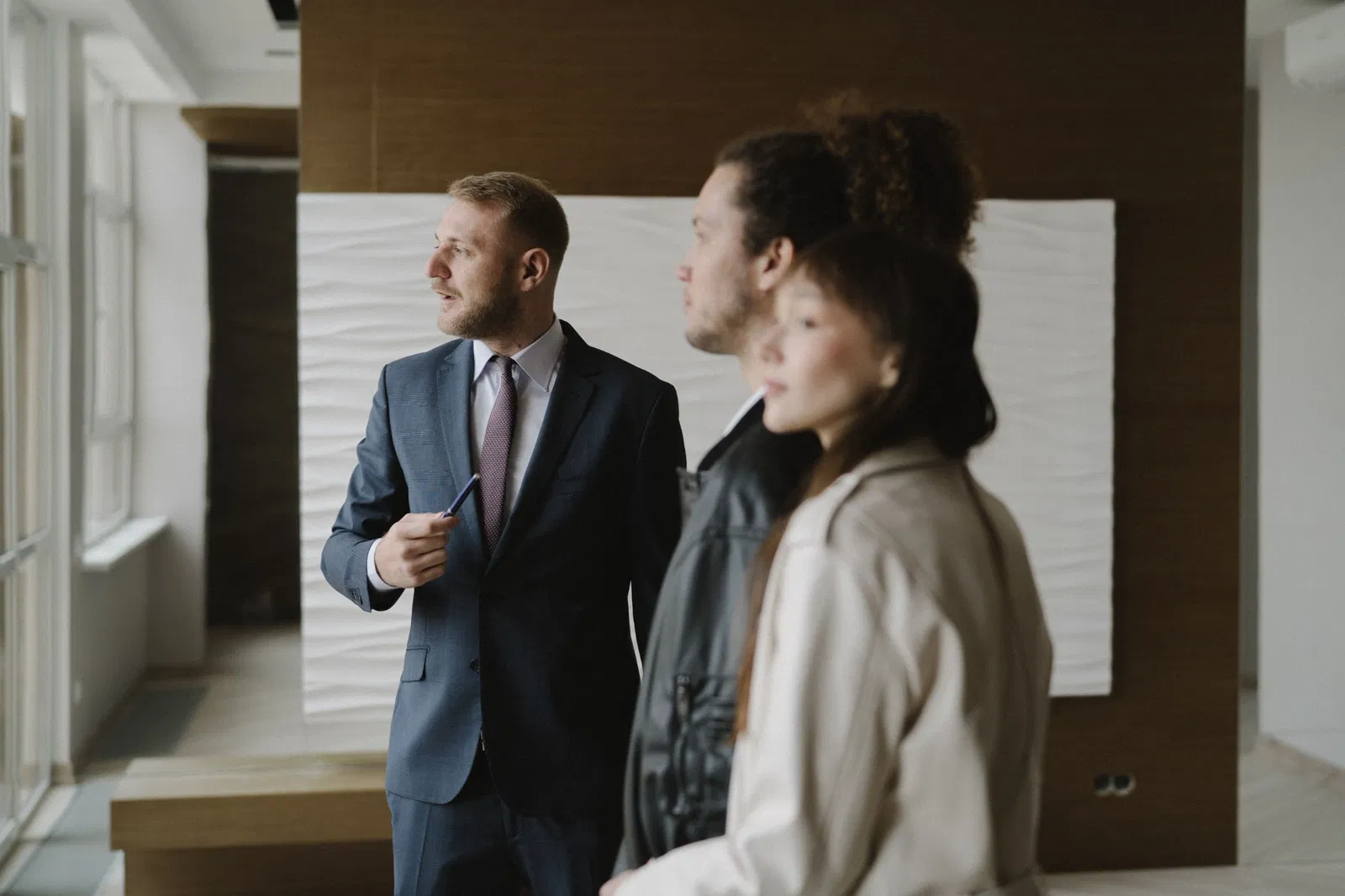 Conseiller immobilier présentant un logement à plusieurs acheteurs potentiels