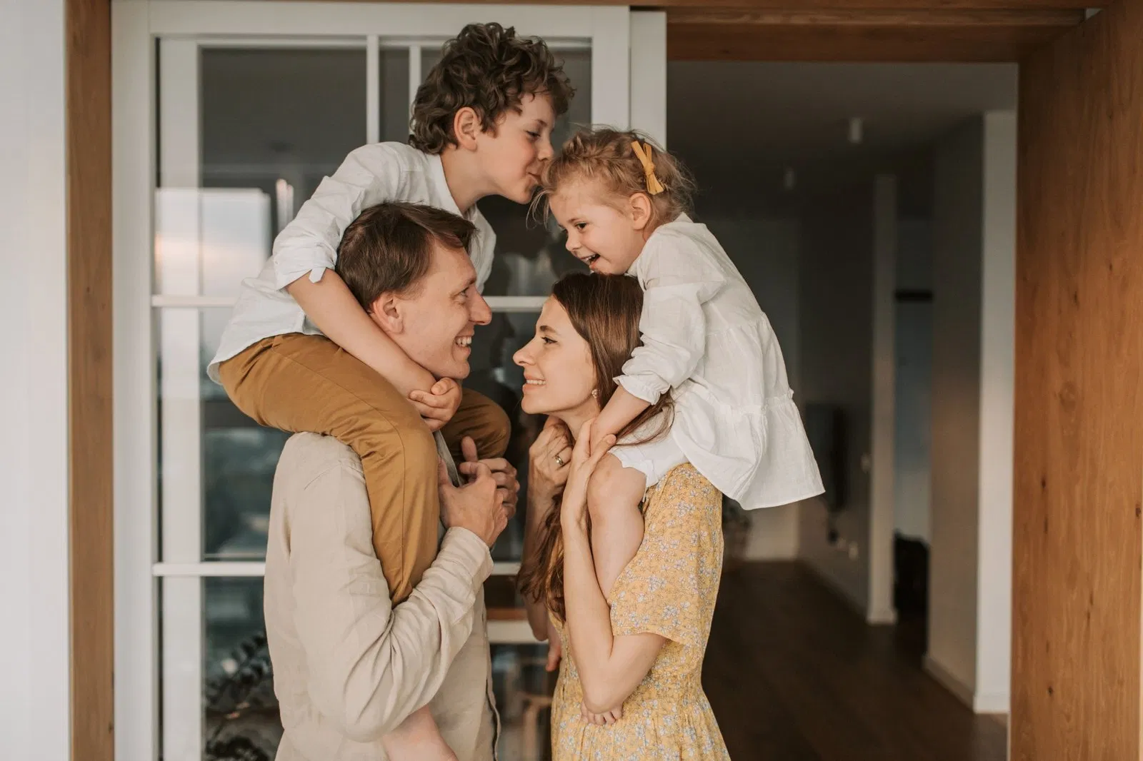 Família reunida em casa com luz suave e ambiente acolhedor.