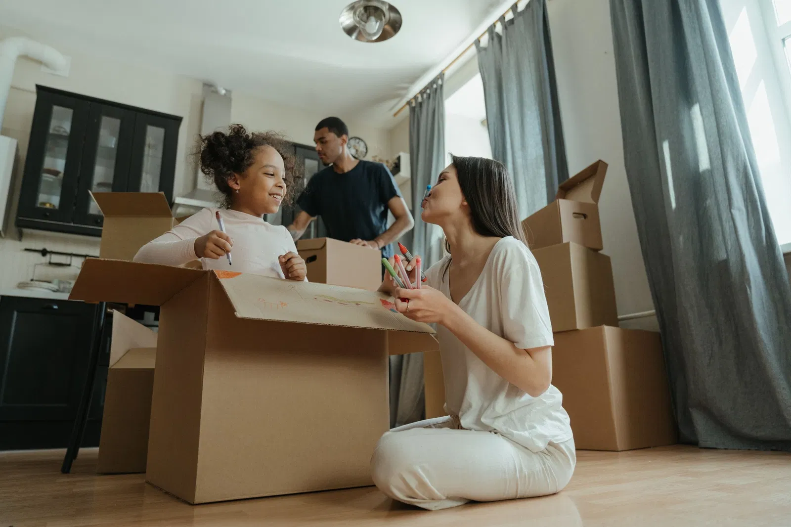 Familia preparando su nueva vivienda entre cajas de mudanza